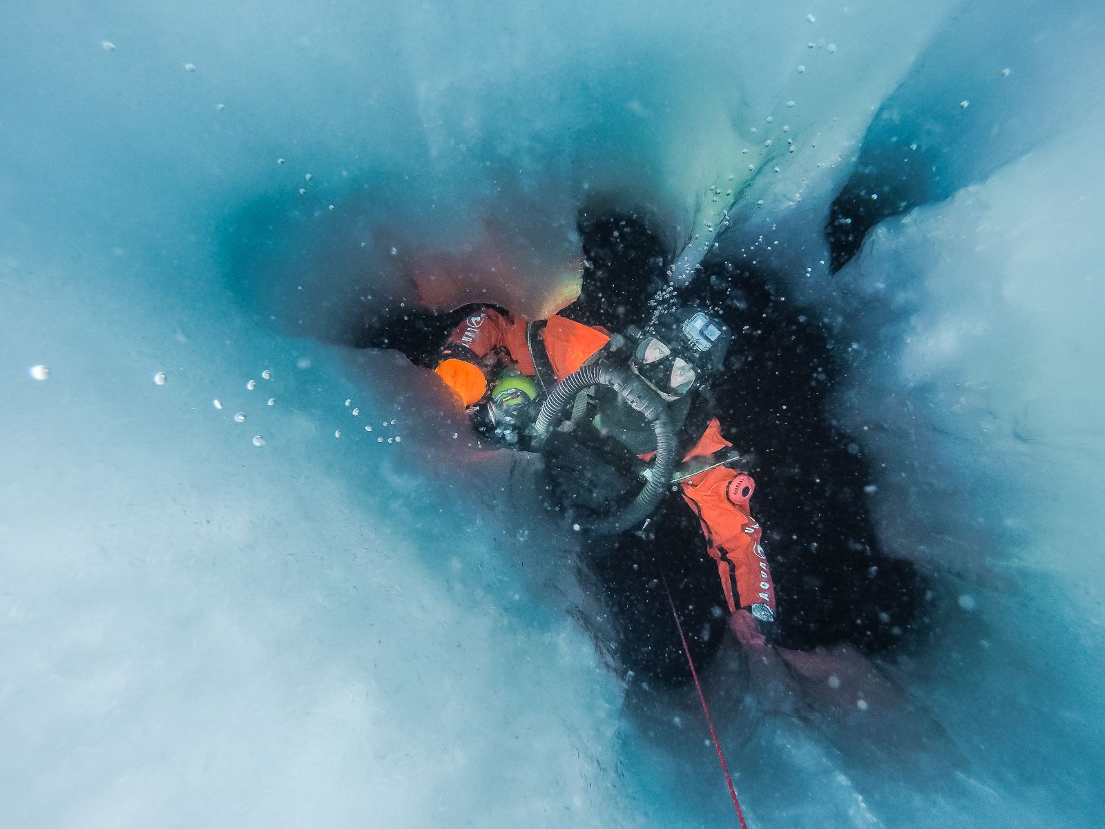 Plongeur en combinaison étanche sous la glace