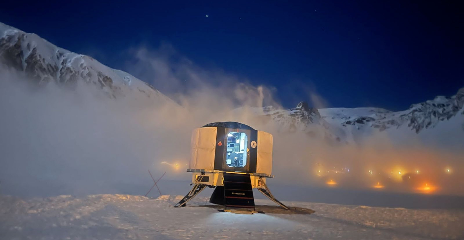 Capsule d’habitat éclairée de nuit dans la neige, lors d’un test